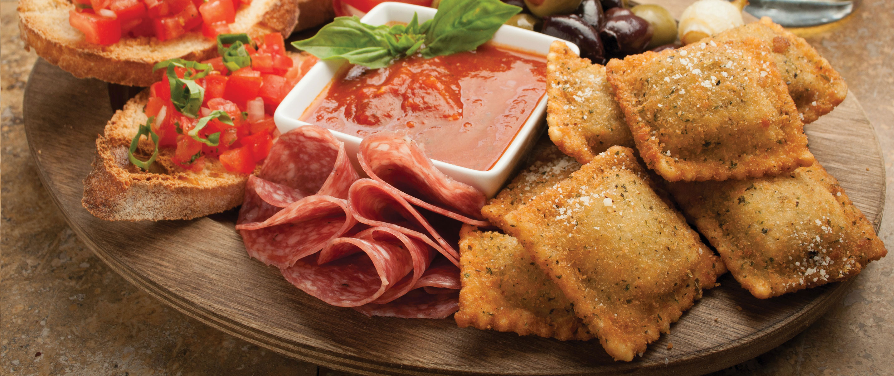 platter with toasted ravioli, salami and olives