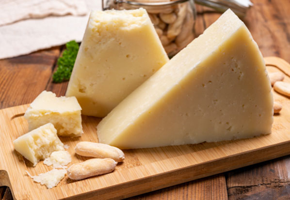 A wedge of Parmesan cheese on a cutting board